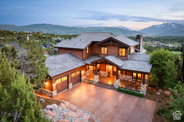 2314 E FLATTOP MOUNTAIN DR 89 Heber City, Utah Nestled within the exclusive Red Ledges, 2314 E Flattop Mountain Drive offers unparalleled mountain living in a magnificent 5007 sq ft estate. Sophisticated design meets the rugged beauty of the Heber Valley, with breathtaking panoramic views of Mount Timpanogos and the Wasatch Range. Meticulous craftsmanship defines the environment, ideal for both tranquil relaxation and memorable gatherings. Expansive open-concept living features soaring wood beam and cedar plank ceilings in the great room, kitchen, and dining room, rich hand-scraped hickory floors, and grand windows framing stunning vistas from every major room. The gourmet kitchen boasts quartz countertops and Thermador appliances, complemented by an elegant wet bar. Enjoy casual dining in the panoramic breakfast nook. Step onto the expansively covered deck with a built-in outdoor kitchen, set against the majestic Wasatch Mountains. The lower level offers a second fully equipped kitchen with a wet bar, perfect for hosting. The unique lower-level family room showcases a 140-gallon marine aquarium with automated systems, a full theater TV with surround sound, and a game table. The lower level also features a relaxing 6-person hot tub on the patio.