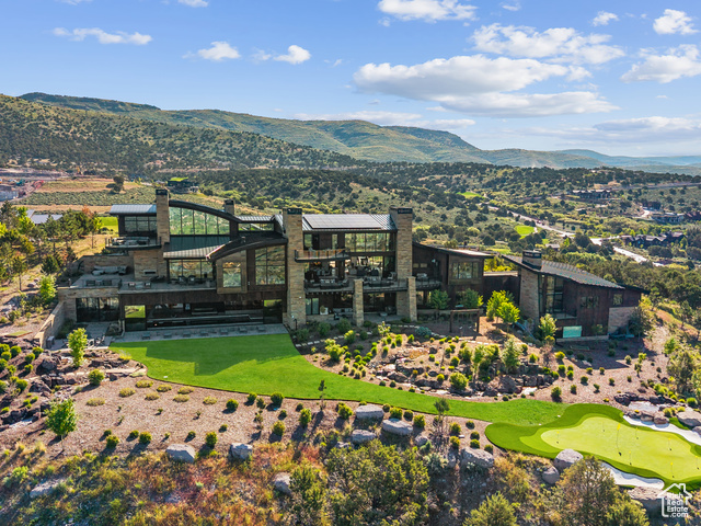 831 N EXPLORER PEAK DR Heber City, Utah Elevated above the rest, this striking mountain estate claims one of the most commanding ridgelines within the coveted Red Ledges gated community, offering panoramic views that sweep across the Wasatch Range and Heber Valley. Designed by visionary architect Michael Upwall and brought to life by the renowned Shawn Johnstun, this exceptional residence blends bold architectural form with the warmth and function of a true legacy retreat. Just 15 minutes from Deer Valley Resort, the home balances alpine seclusion with resort-level accessibility. Nearly 21,000 square feet of thoughtfully designed living space offers an extraordinary backdrop for both intimate moments and grand entertaining. Every detail has been considered, with timeless materials, flawless craftsmanship, and seamless indoor-outdoor flow throughout. World-class amenities include an indoor sport court, a fitness suite with private sauna and steam rooms, a 50-foot indoor pool and spa, and a 2,000 square foot rooftop putting green with sweeping alpine vistas. A state-of-the-art indoor golf simulator ensures year-round play, no matter the weather. Expansive terraces with fire features and built-in audio create the perfect setting for relaxed mountain evenings and unforgettable events. The home offers 7 bedrooms and 11 bathrooms, including a serene primary wing, a two-bedroom private guest casita with full kitchen and garage, and a whimsical custom bunk room designed to host generations of guests in style. Offered fully furnished with custom-selected pieces and artwork, the interiors are ready for effortless move-in. The grounds are as extraordinary as the interiors, with cascading water features, massive Wyoming boulders, manicured lawns, and a private 75-yard par 3 golf hole with an infinity-edge green. It's all surrounded by the natural beauty and stillness of the mountain landscape. Red Ledges premier club amenities include the Jack Nicklaus Signature Golf Course, ski and adventure clubs, fine dining, equestrian center, pools, tennis and pickleball, fitness centers, and a welcoming member community. This is more than a home-it's a legacy estate designed to elevate every chapter of life in the mountains. Golf Park Membership Available.