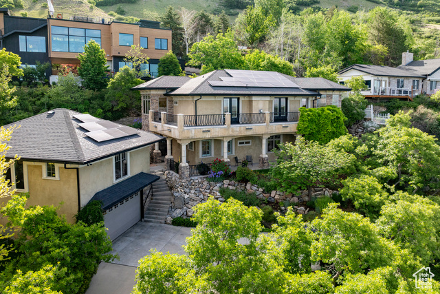 "This stunning, custom home along the east bench in Provo, with separate apartment over the garage, offers unobstructed panoramic views of the entire Utah Valley, showcasing breathtaking sunrises and sunsets. Enjoy the annual Stadium of Fire fireworks from your private balcony, just 3 miles from Brigham Young University and a short 17-minute drive to Sundance Ski Resort.   The main house is designed for luxury and accessibility. Custom woodwork throughout adds timeless elegance. Each of the 3 bedrooms has its own en-suite bath, and the kids' room is a magical retreat with a loft. The primary bedroom walks out onto the patio, has a large walk-in closet and spacious ensuite bath. The chef's kitchen features an induction cooktop (with gas hookup option) for a superior cooking experience, double wall ovens, large island with granite countertops, and spacious walk-in pantry.   Step outside to a masterfully designed yard. Enjoy the private space with peaceful waterfall and mature, drought-tolerant landscaping. Enjoy the beautiful wildlife in this nature lover's paradise. Sit on the spacious deck or patio and enjoy the magnificent views.  The apartment over the garage features a large kitchen with island and granite countertops, one spacious bedroom and a bathroom. Stay comfortable with the Mitsubishi mini-split A/C and heat pump, plus a Bryant furnace for versatile climate control. The 2 car garage below maintains a comfortable 55-70 year-round, has a top-rated 40-amp Grizzl-E Level 2 EV charger, and a hot/cold hose hookup. The driveway has ample parking, which is ideal in Provo.  Security is seamless with CAT5 POE-wired Amcrest video surveillance, accessible worldwide via smartphone with local recording and no subscription fees. Live feeds can cycle on your TV.  This energy-efficient masterpiece boasts a 100% owned solar system, eliminating summer power bills even with A/C and EV charging. The home features R-60 ceiling insulation, 6" wall studs for maximum insulation, and double-pane, low-E windows and doors for year-round comfort. A tankless water heater and Belkin/WEMO smart lighting system, controllable via smartphone, enhance efficiency and convenience. Don't miss this rare opportunity to own this thoughtfully designed, eco-friendly home. Furnishings are available separately. Call today for private showing!"