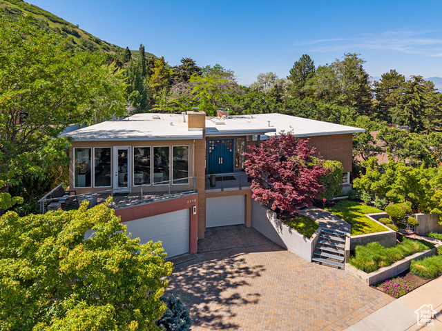 2992 E SAINT MARYS CIR Salt Lake City, Utah If spectacular views and the beauty of nature captivate you, this extraordinary home at the top of St. Marys is the home for you. Thoughtfully renovated to maximize its impressive mountain and city views, nearly every room is designed to bring the outdoors in. Floor-to-ceiling windows, a striking butterfly roof, and an open, modern aesthetic make this home truly one of a kind. Step inside to an airy, light-filled entryway with skylights, setting the tone for the incredible spaces beyond. Gourmet kitchen features professional-grade appliances, solid walnut cabinetry, honed black granite countertops, and a passthrough pantry with ample storage. A double-sided sandstone fireplace seamlessly connects the kitchen, family room, and formal dining area-perfect for both cozy nights in and elegant entertaining. The primary suite is a luxurious retreat, complete with a sitting area, wall of windows with motorized shades, and a double-sided fireplace leading to the spa-like ensuite. Indulge in heated floors, soaking tub, steam shower w/bench, stackable washer & dryer, dual sink vanity, and oversized walk-in closet. The walk-out lower level offers even more to love, with two spacious bedrooms (one ensuite), two bathrooms, a family room with a bar and steam fireplace, a dedicated theater room & equipment room, and laundry with sink & refrigerator. Outside, a sandstone patio with a firepit and a built-in motorized screen makes for magical movie nights under the stars. The garage space is equally impressive, accommodating three cars across two garages, featuring epoxy floors, built-in cabinets, a workshop, hot & cold water spigots, drainage, and a climate-controlled venting system. And then there's the backyard-a private arboretum unlike any other. Explore sandstone walkways, limestone stairs, waterfalls, a stream, a putting green and driving range (net included), raised garden beds, firepits, and a Trex deck-all surrounded by lush, perennial landscaping and mature trees. Additional features: whole-house audio with speakers & control panels in every room, heated floors in 4 bathrooms, 4 gas fireplaces + 1 steam fireplace, 75-gallon water heater, and Smart home controls for lighting, HVAC, security cameras & irrigation sprinklers. Included in the sale: interior & exterior cameras, Ring doorbell, tv's in office & lower level bedroom, 2 sets of washer/dryer, refrigerator in laundry, theater seating & equipment, BBQ, deer yard art, shed, large pots with trees, outdoor movie screen and driving range equipment. Square footage figures are provided as a courtesy estimate only. Buyer is advised to obtain an independent measurement.
