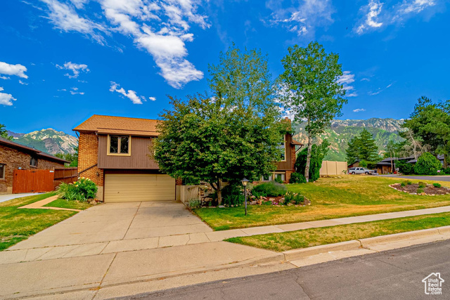 10365 S 2505 E Sandy, Utah Wonderful Sandy home, sitting on a corner lot, with stunning views of the valley to the west and views of the mountains to the east. Nestled at the top of Sego Lily, the neighborhood is quiet and peaceful. The home sits on .25 acres, but it feels much larger due to the fact there is extra ground behind the east lot line that is owned by the water district, but is allowed to be used by the homeowner, providing more privacy and less obstructed views of the mtns. Don't overlook the beauty of a large patio on the east side of a home, grabbing afternoon and evening shade, with a view like this!!! Step inside this expansive bi-level home to find vaulted ceilings, large windows (many of them recently replaced), extra wide hallways, and generous sized bedrooms. Newer carpet upstairs and brand new carpet downstairs. Roof was replaced in 2020. Newer AC and furnace. Newer water heater. Large kitchen with stunning marble counter tops, stainless steel appliances, and a pantry! Fully remodeled master bathroom. Extra deep garage includes a workshop area, work bench area, and extra storage! Access to the beautiful dimple dell trail system is across the street to the south...giving you quick access to nature, recreation, and beauty right outside your front door. This area is highly desirable and homes move quick. Schedule your tour today!