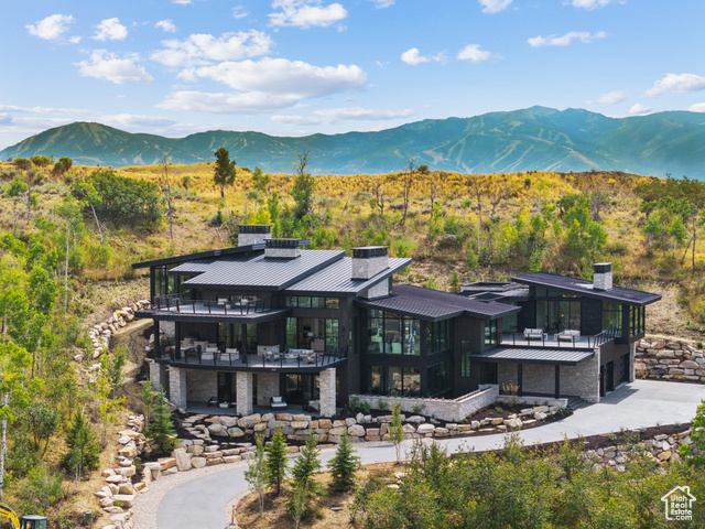 Newly completed turn-key contemporary masterpiece showcases the exquisite design by Habitations Design Group and beautiful furnishings by Midway Design & Interiors. Built by Summit Contractors, this gorgeous home offers a luxury lifestyle within the amenity-rich Promontory gated golf community. Welcome guests through the ten-foot door that pivots into the grand foyer with a stone water feature. Large windows invite Aspen Camp's natural light and fully landscaped vistas into the home, accented by hardwood floors, soaring ceilings, and custom lighting. Entertain in the great room with golf course to mountain views. The gourmet kitchen with Wolf appliances features custom cabinetry with a hidden butler's pantry adjacent to a glass-encased wine room. Floor-to-ceiling sliding doors open to multiple patio spaces, extending the living and entertainment areas. Enjoy the natural tranquility of aspens, a water feature stream, and a hot tub on the private back patio. Follow the breezeway to the private primary bedroom wing, complete with a gas fireplace, a lounge area, and a spa bathroom with windows to the natural setting and stream, a soaking tub, and a steam shower. The main level also hosts a guest suite and a staircase to the sky level dedicated office, guest room, and deck. On the lower level, family and guests will gather in the large family room with a game area, wet bar, guest suite, bunk room, and wellness retreat featuring a sauna and a cold plunge.  Additional luxury conveniences abound with radiant heat throughout the home, a laundry room on each level, a water dispenser and lockers pre-wired for boot warmers in the mud room, and an oversized garage with a pressure washer and a dog wash. Golf Membership available.